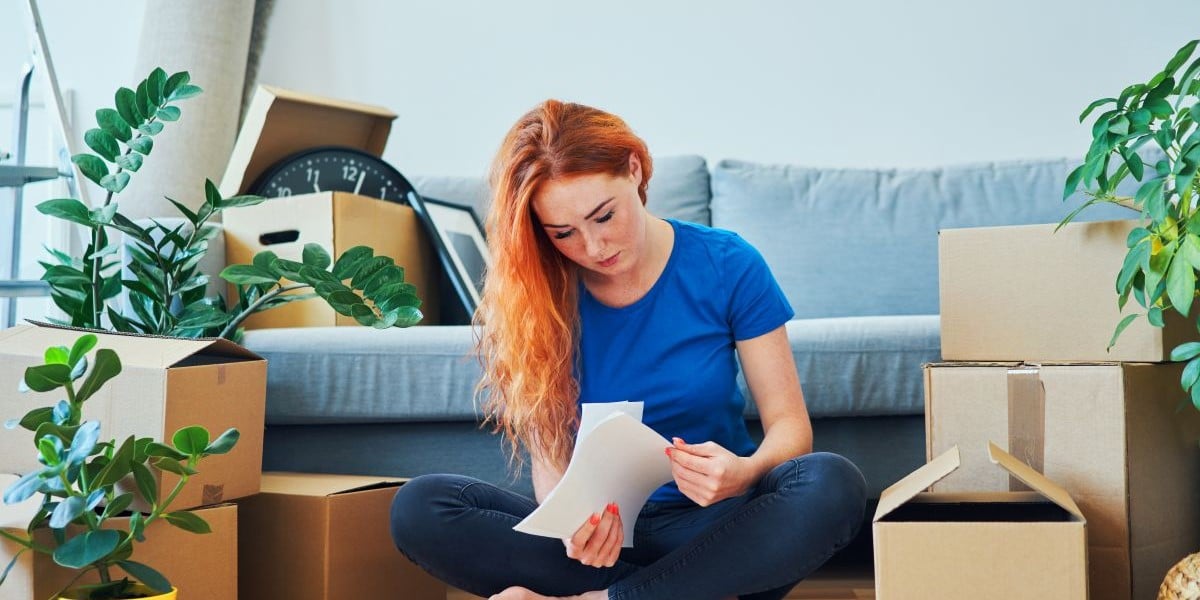 femeie verifica documente intr-un apartament de inchiriat