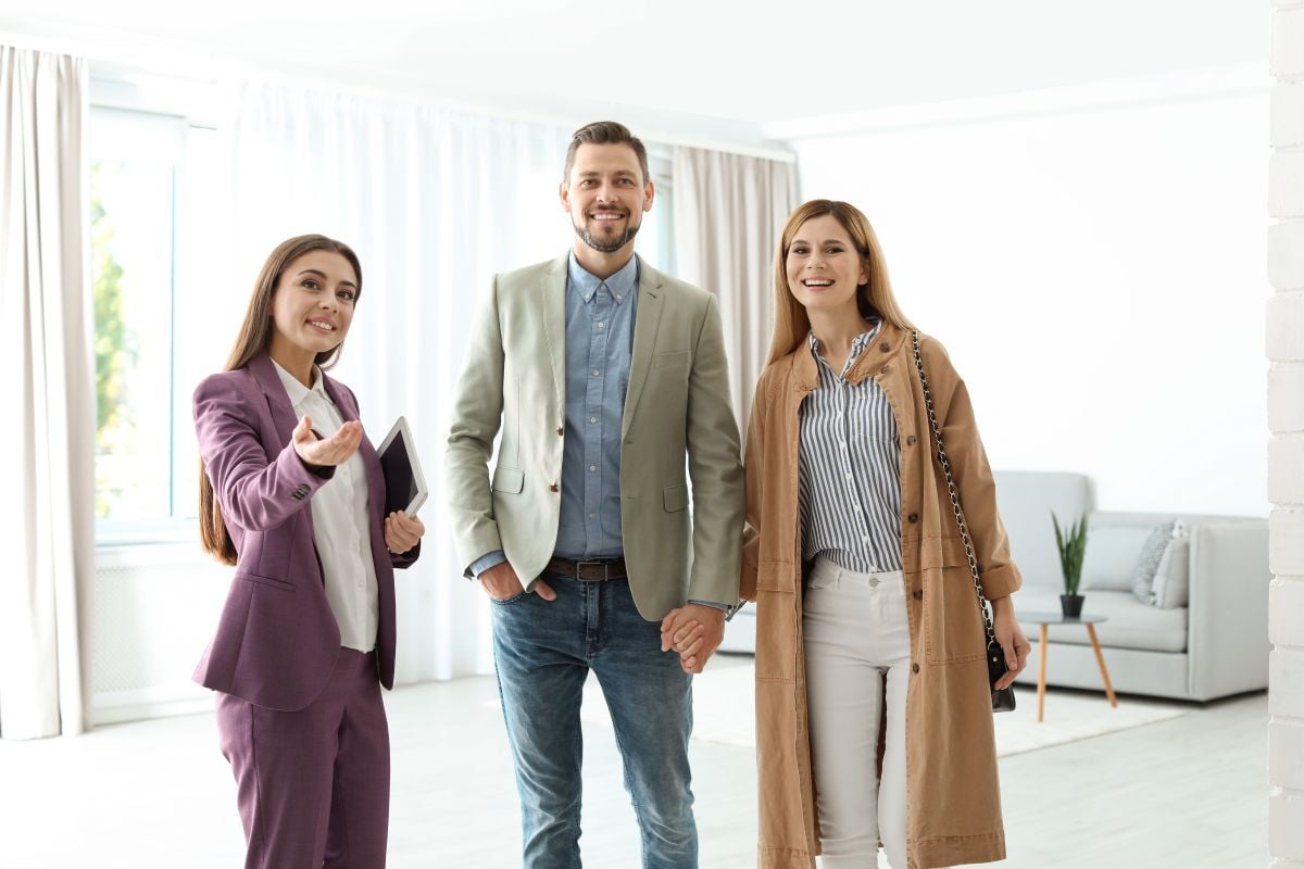 o femeie si un barbat la vizionarea unui apartament alaturi de un agent imobiliar