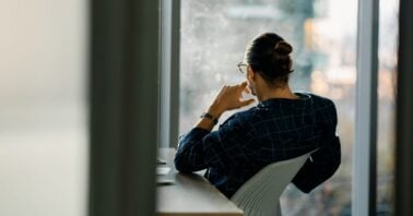 barbat priveste pe geamul apartamentului
