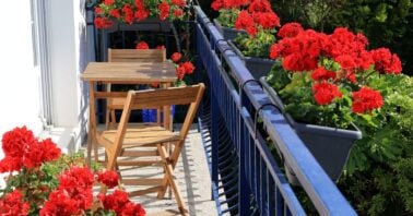 balcon de mici dimensiuni amenajat cu mobilier si flori