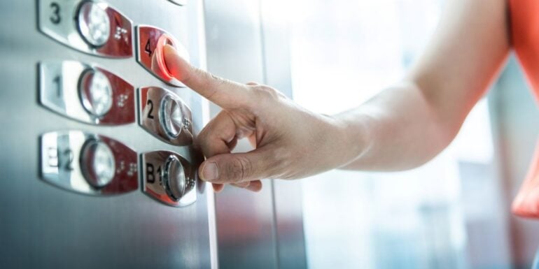 femeie apasa pe buton in lift