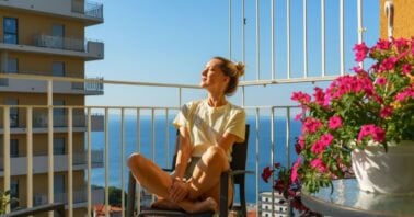 femeie vara pe balconul apartamentului