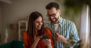 cuplu analizeaza pe telefon oferte de chirii pentru apartamente